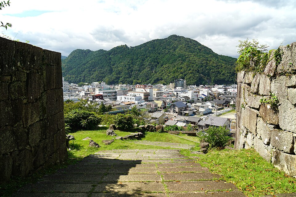 2017年撮影、新宮城の石垣越しに見る町と山